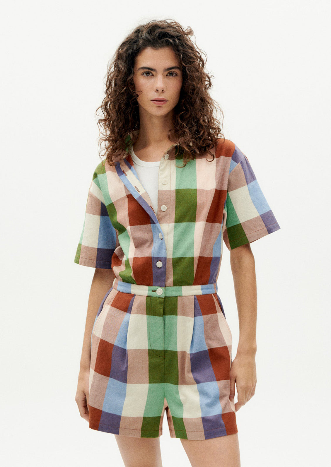 A woman wearing a romper in colorful madras cotton.