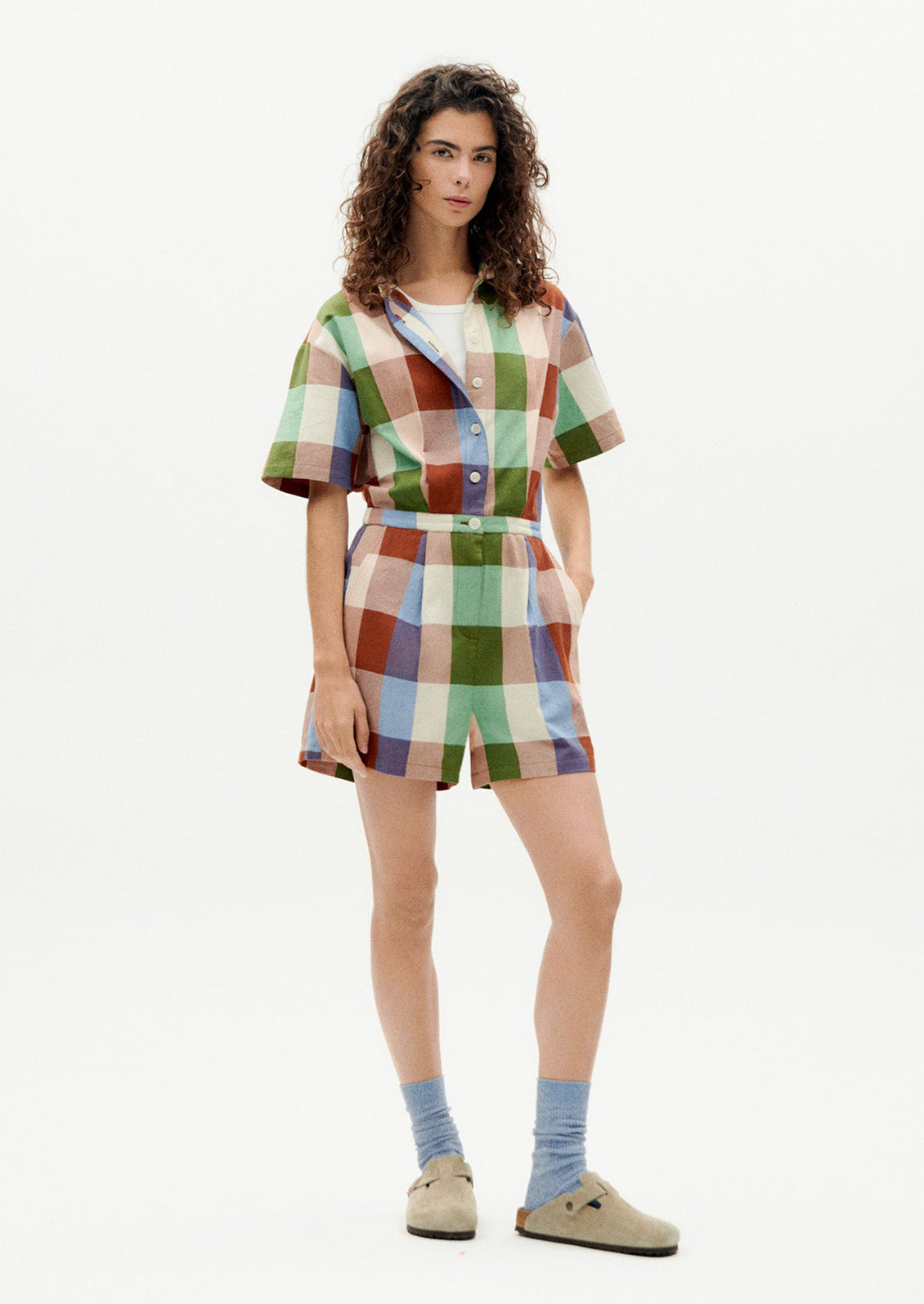 A woman wearing a romper in colorful madras cotton.