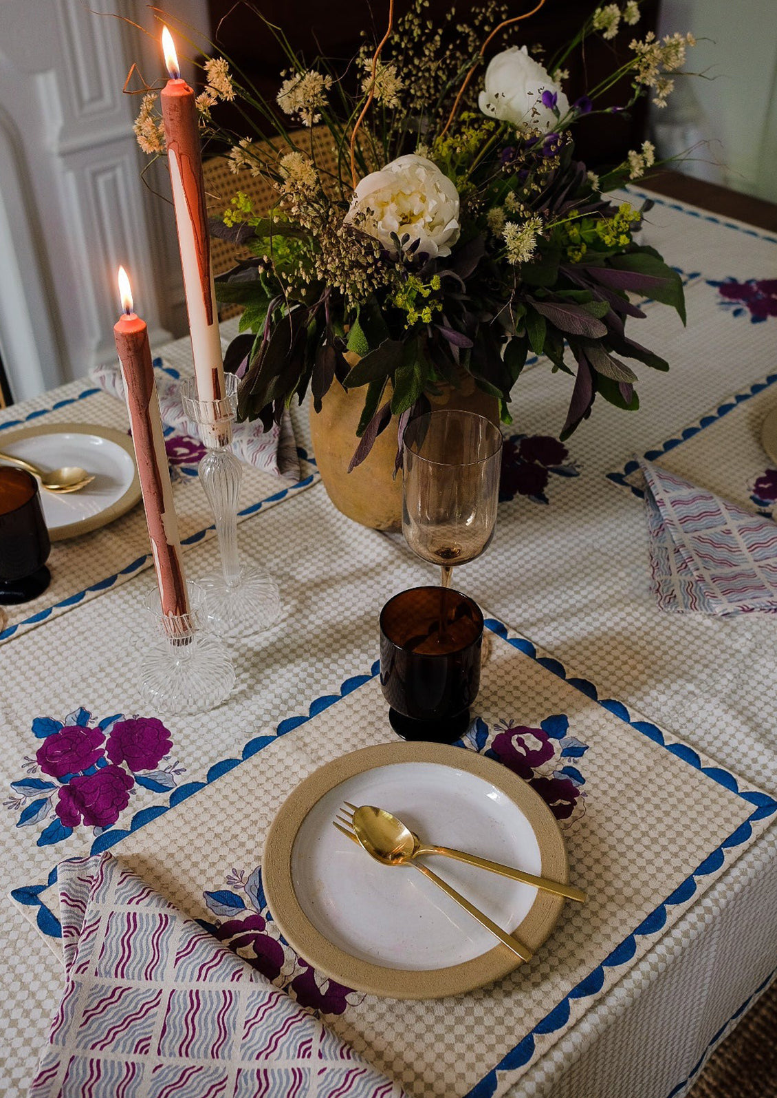 A block printed placemat in wine, blue and beige color palette.