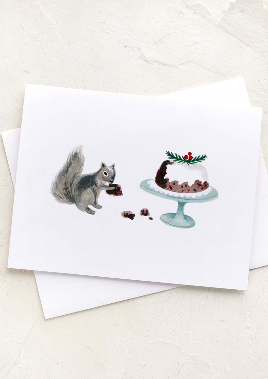 A greeting card with illustration of a squirrel eating holiday fruitcake off a platter.