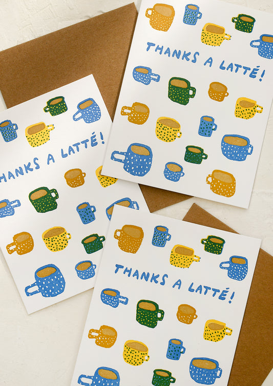 A card with illustration of coffee mugs, text reads "Thanks a latte!".