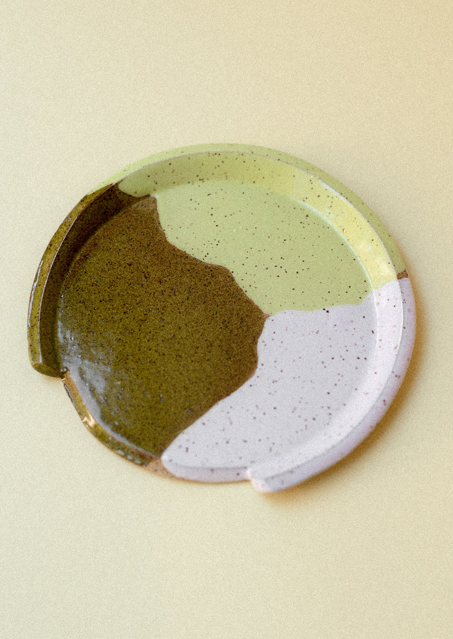 A ceramic spoon rest with playful paint pool pattern.