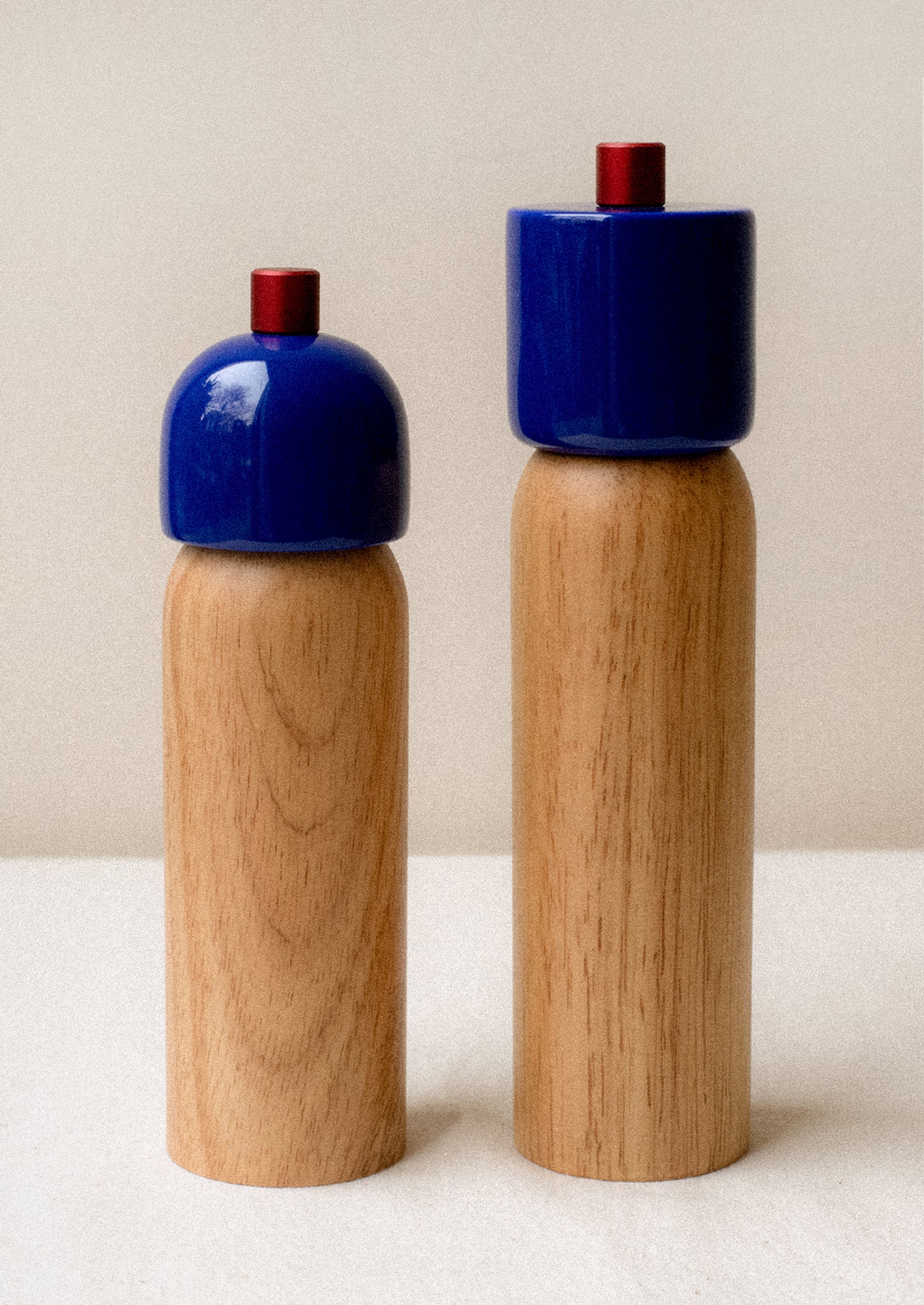 A pair of rubberwood spice grinders with lacquered cobalt blue top.