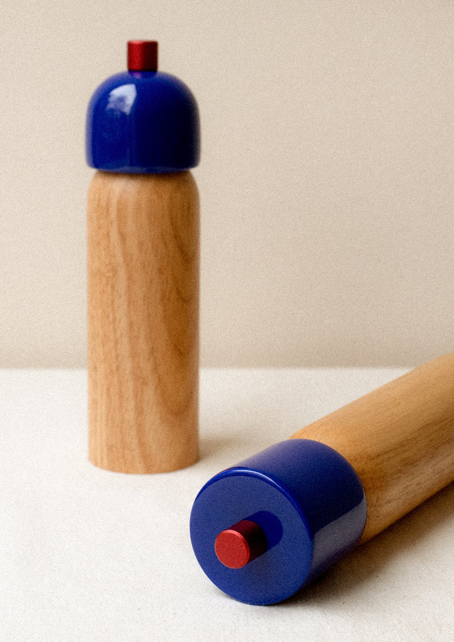 A pair of rubberwood spice grinders with lacquered cobalt blue top.