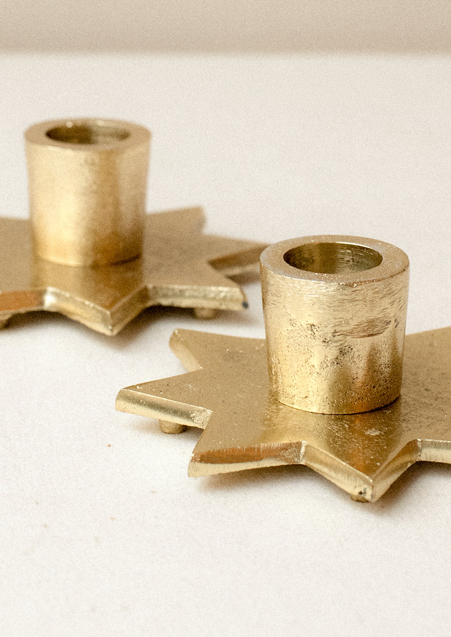 An eight-point star shaped taper candle holder in gold finish.