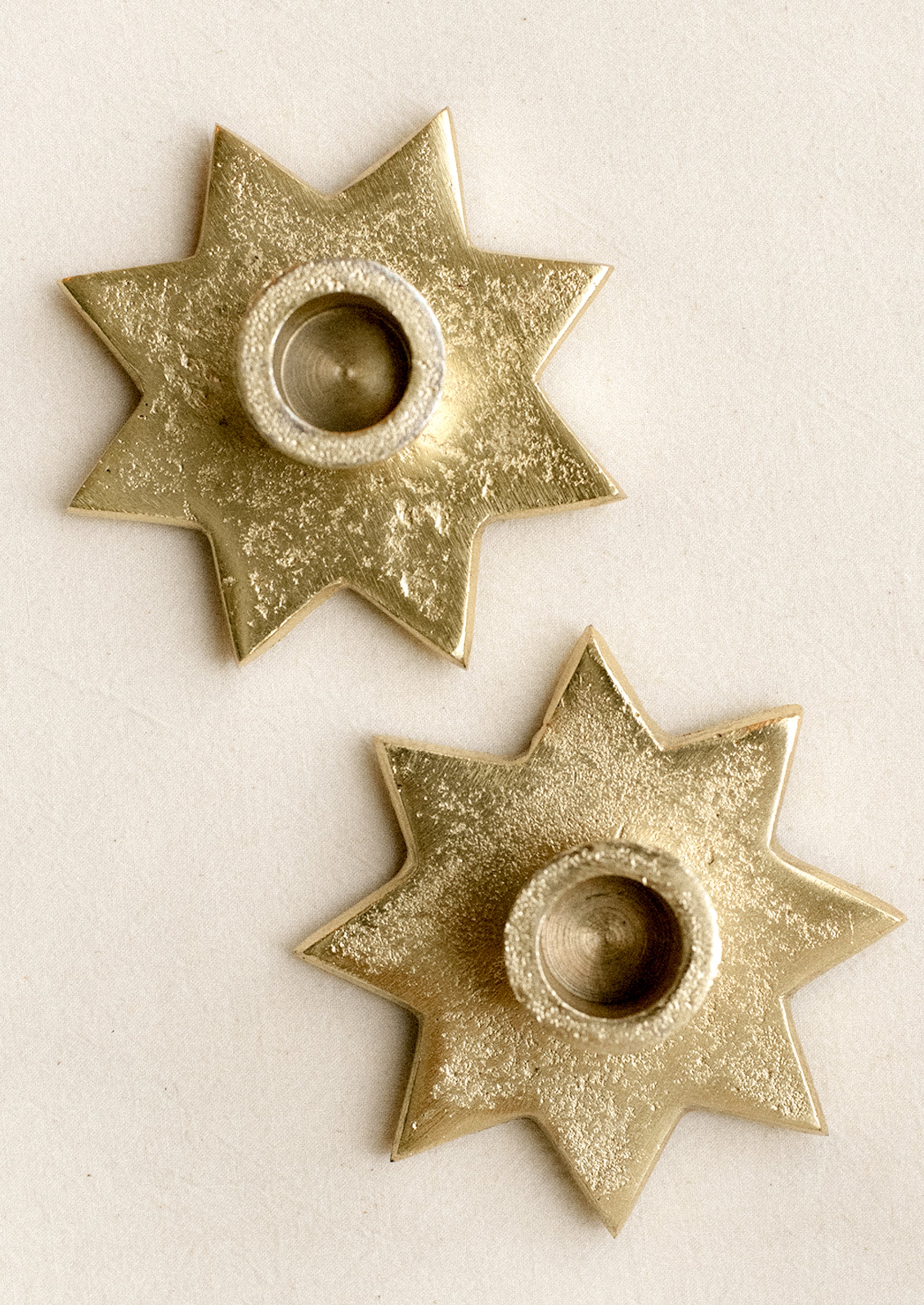 An eight-point star shaped taper candle holder in gold finish.