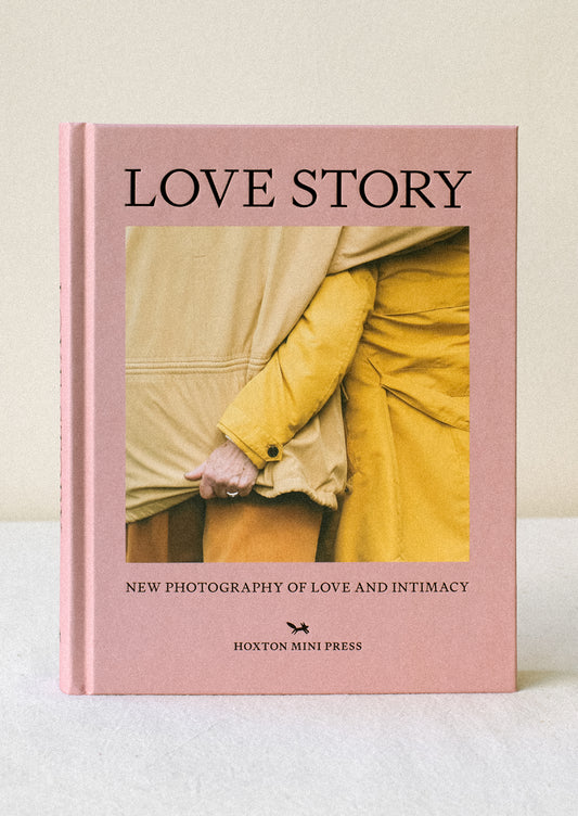 A hard cover book in pink, with image of a couple arm in arm.