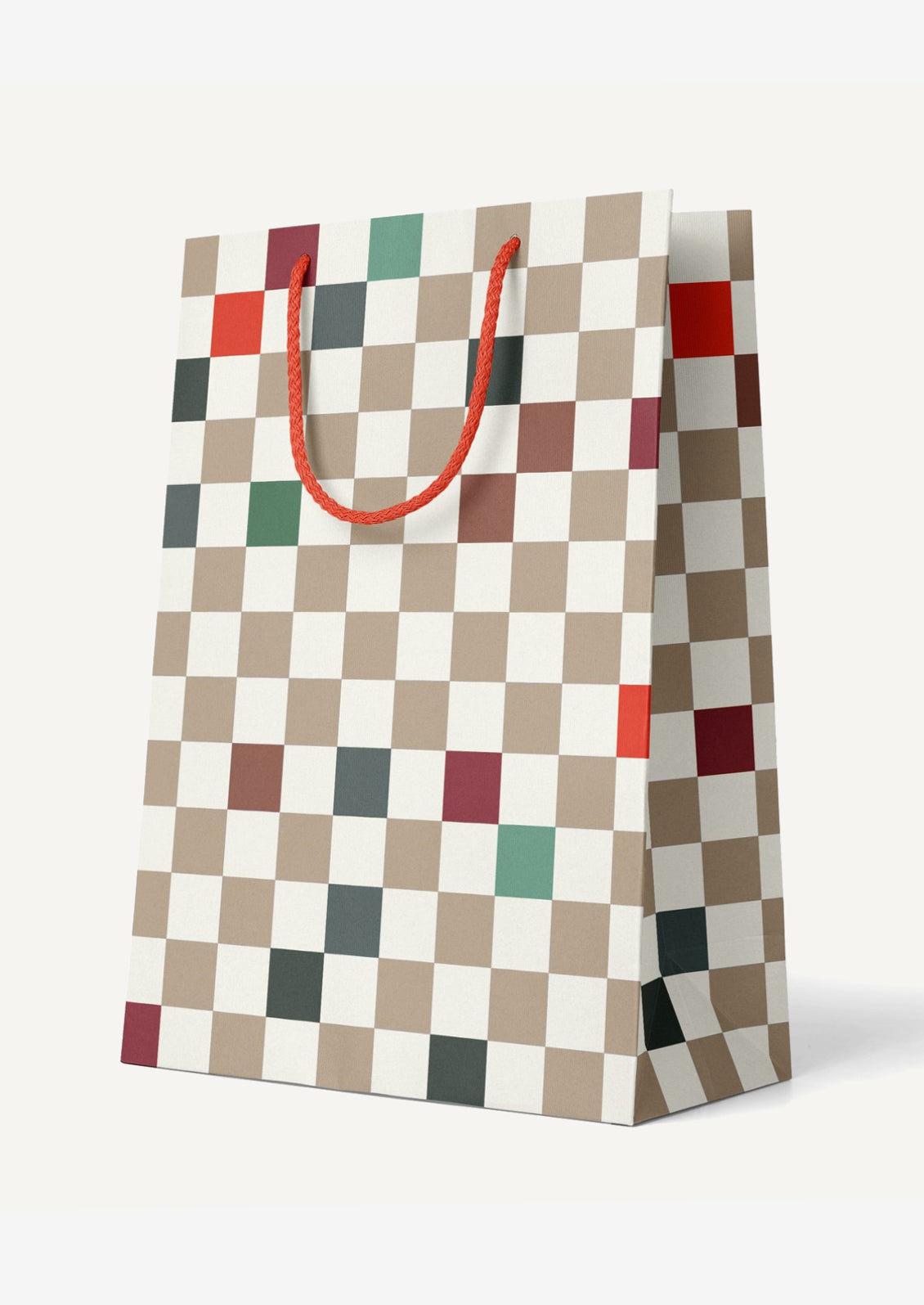 A large printed gift bag in white with beige, red and green checker pattern.