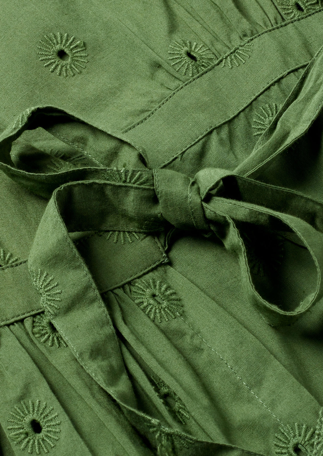 Green cotton with tie closure and sun-shaped eyelet embroidery.