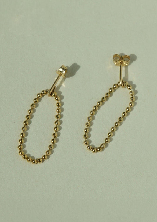 A pair of gold post back earrings with ball chain loop front.