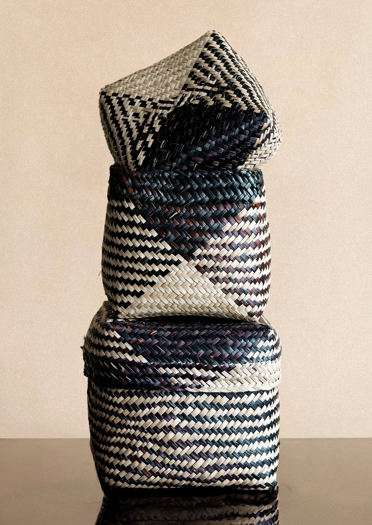 Woven seagrass baskets in square shape with woven black diamond pattern.