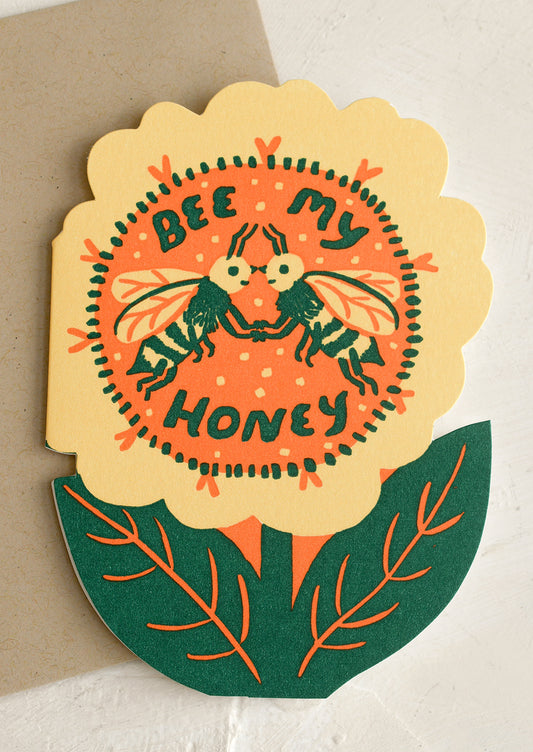 A flower shaped card with text on front reading "Bee My Honey".