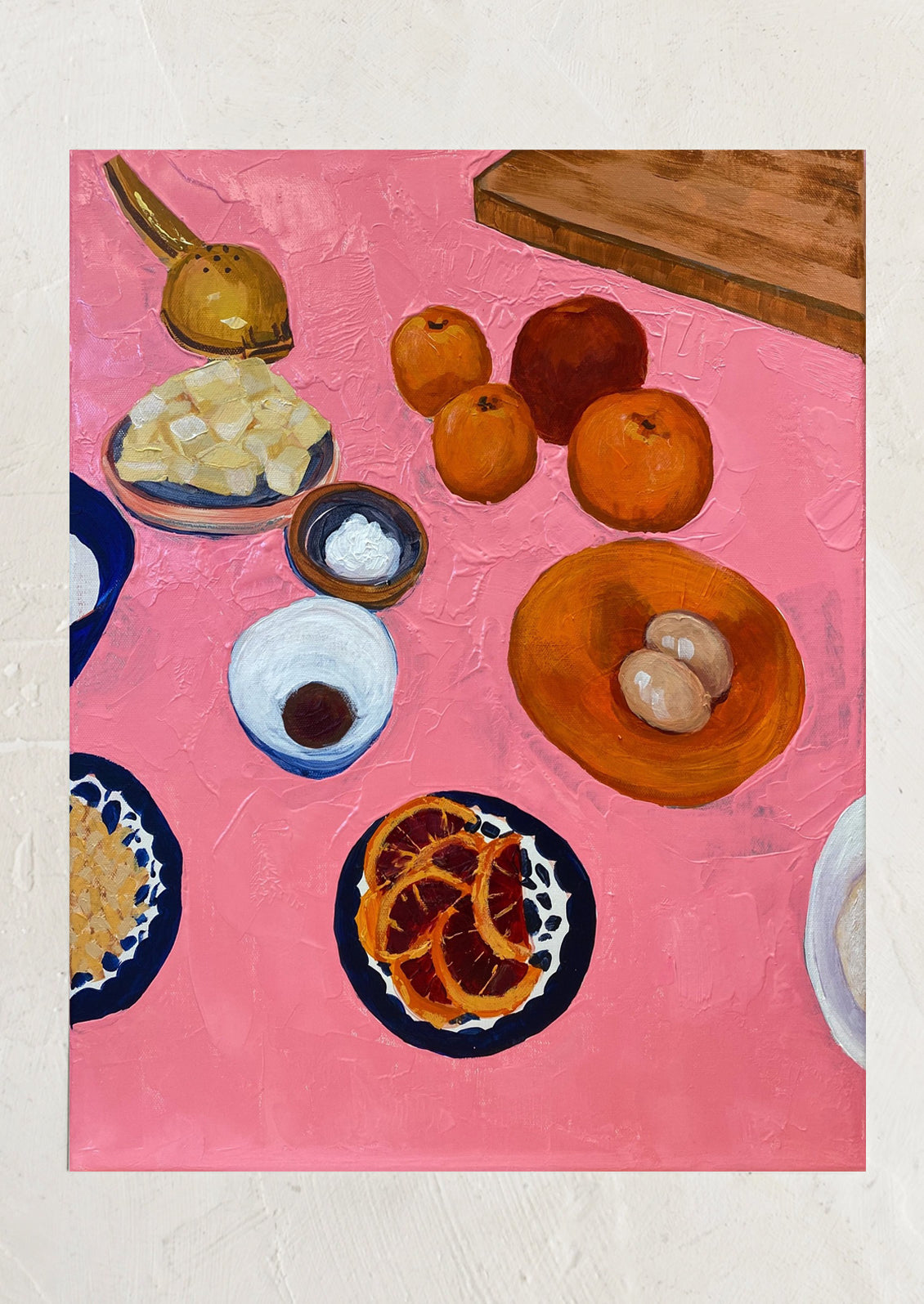 An art print of a painting depicting oranges, eggs and butter on a neon pink background.