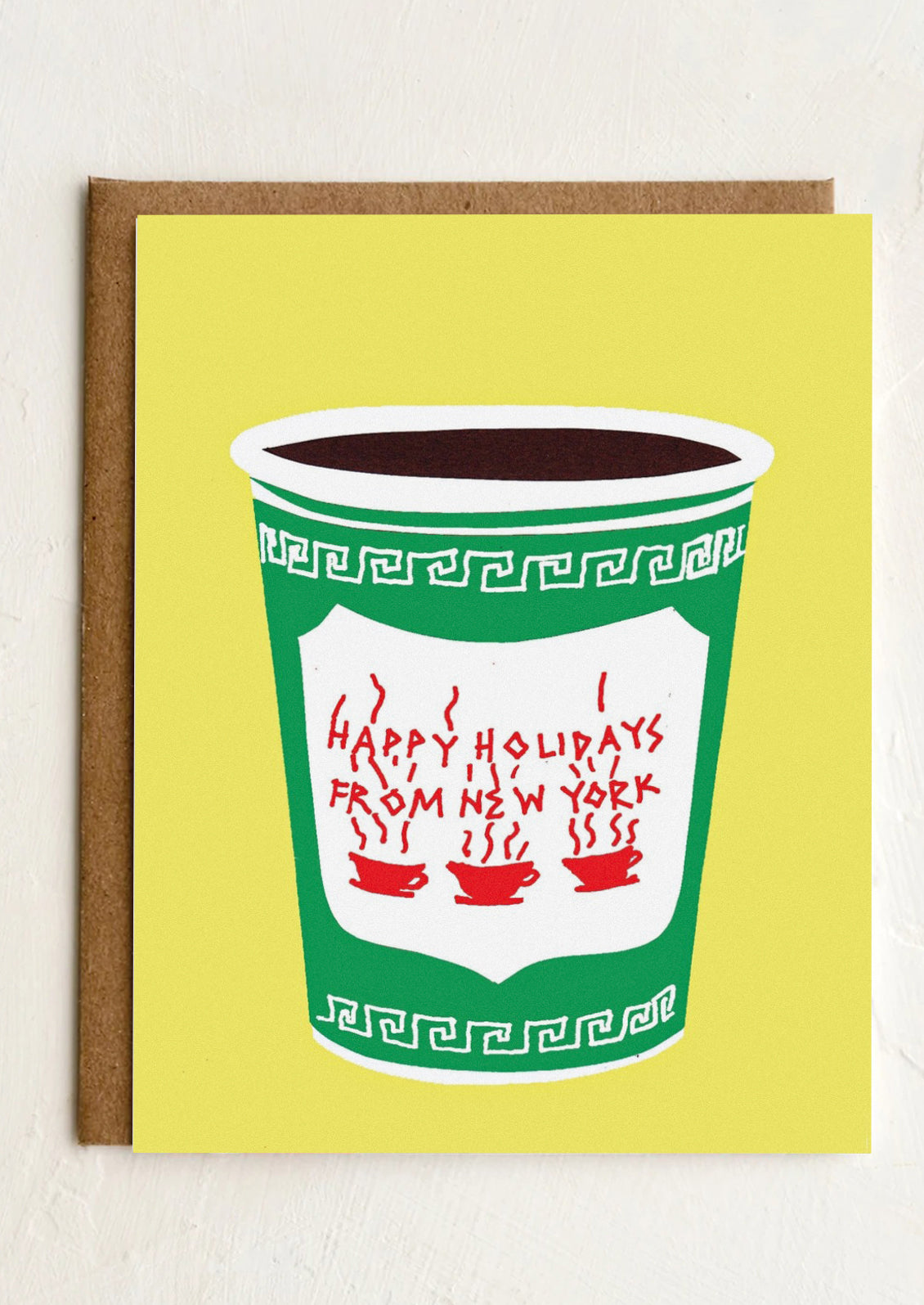 A yellow card with bodega style coffee cup image, text reads Happy Holidays From New York.