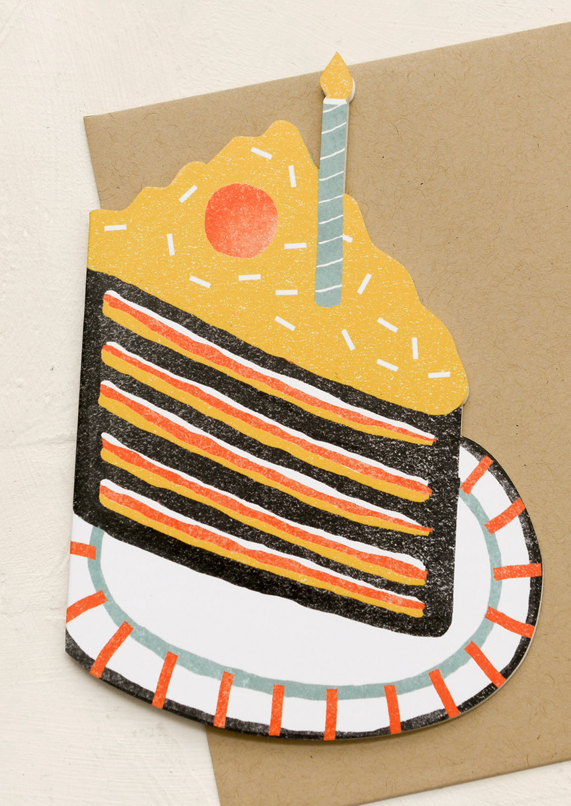 A diecut card in shape of cake slice with birthday candle.