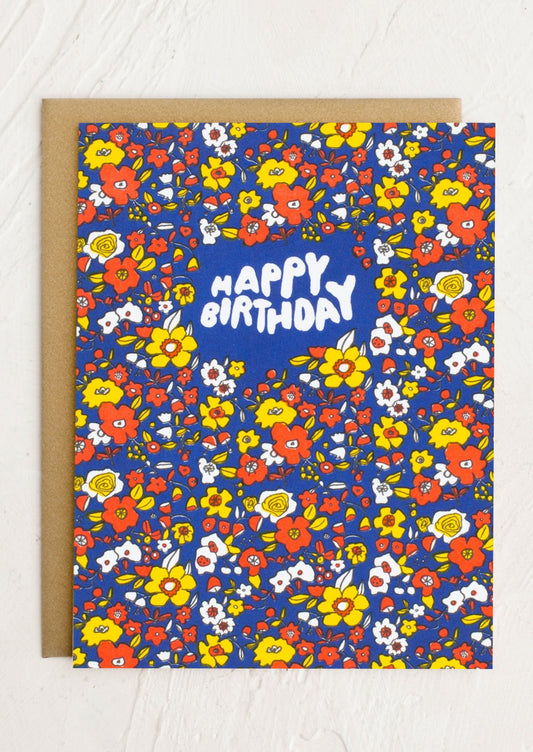 A blue birthday card with yellow and red floral pattern, text reads "Happy Birthday".