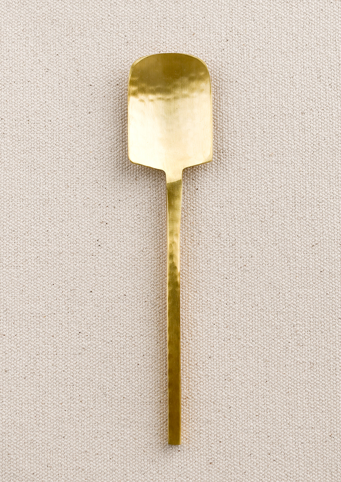 A small canape spoon in hammered gold finish.