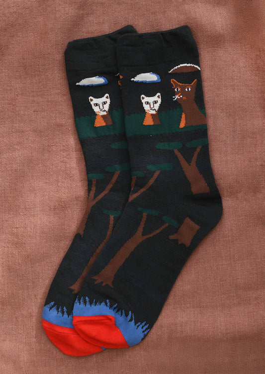 A pair of black socks with cat and tree print.