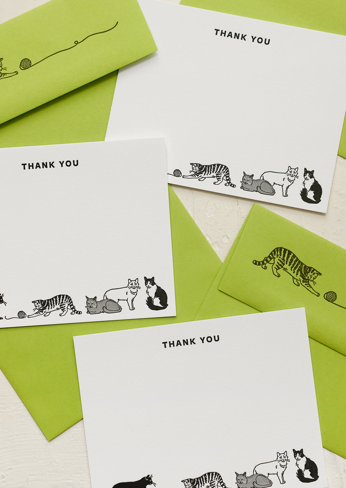 Cat printed white notecards with text at top reading "THANK YOU", paired with cat printed green envelopes.