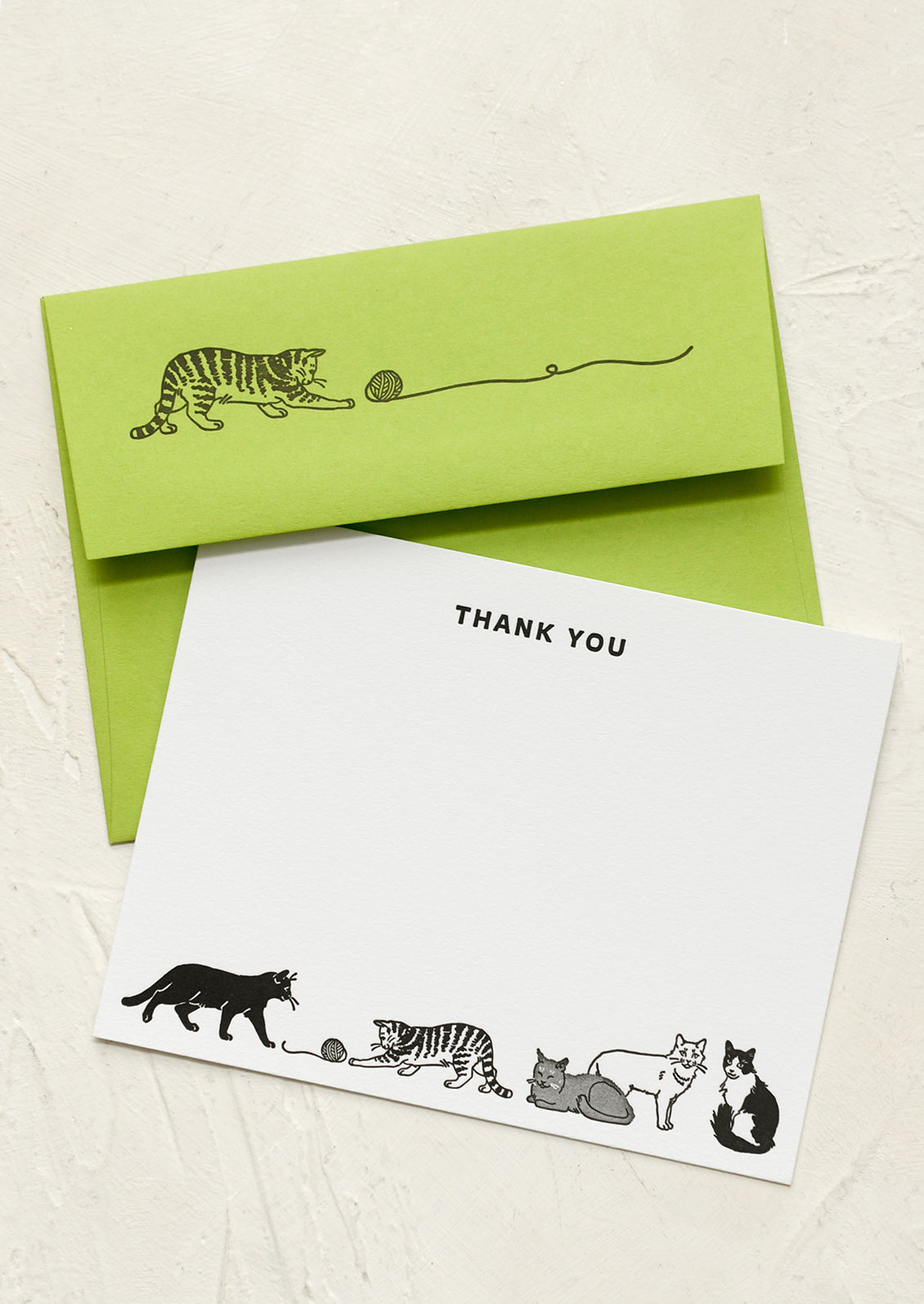 A white notecard printed with cats, text at top reads "THANK YOU", paired with cat printed green envelope.