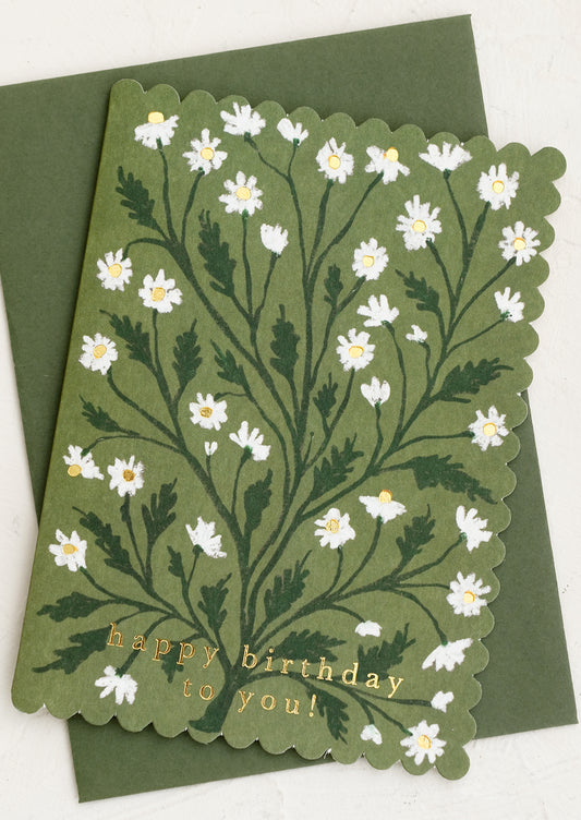 A scalloped edge birthday card with chamomile floral print on olive green.