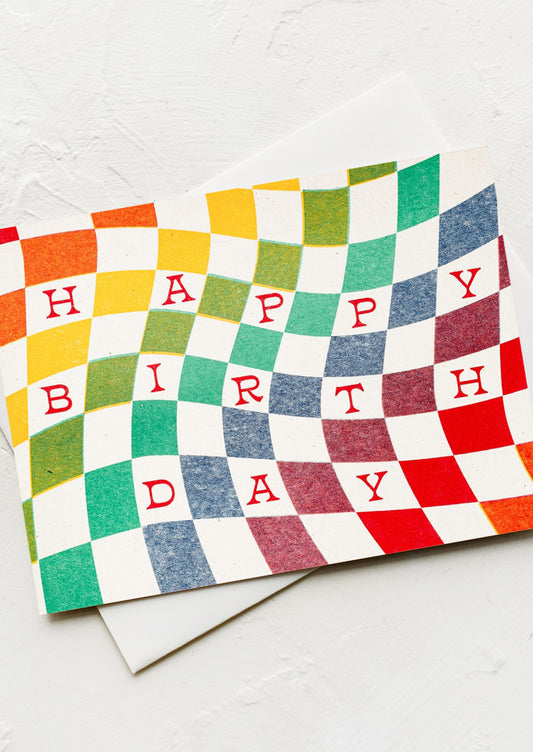 A rainbow wavy checker print card reading "Happy Birthday".