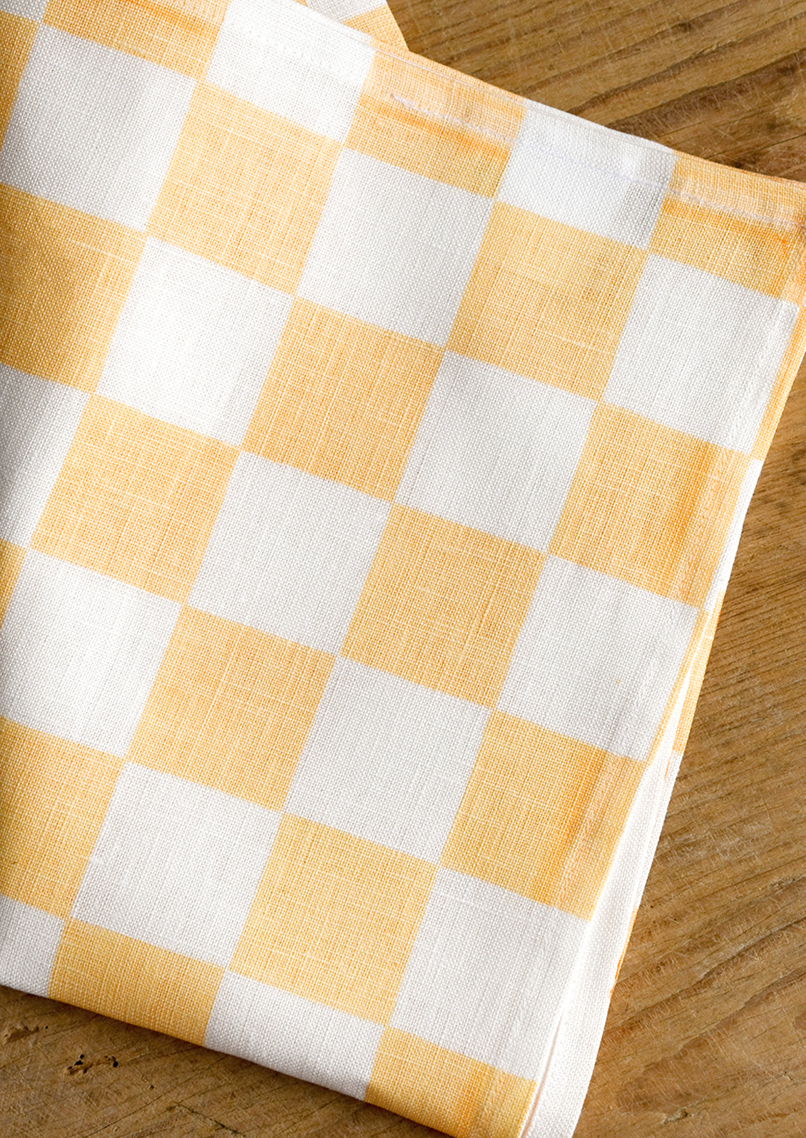 A checkered linen tea towel in apricot and white.