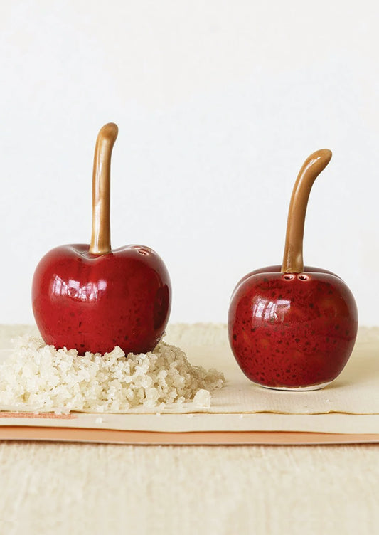 A pair of red cherry shaped salt and pepper shakers.