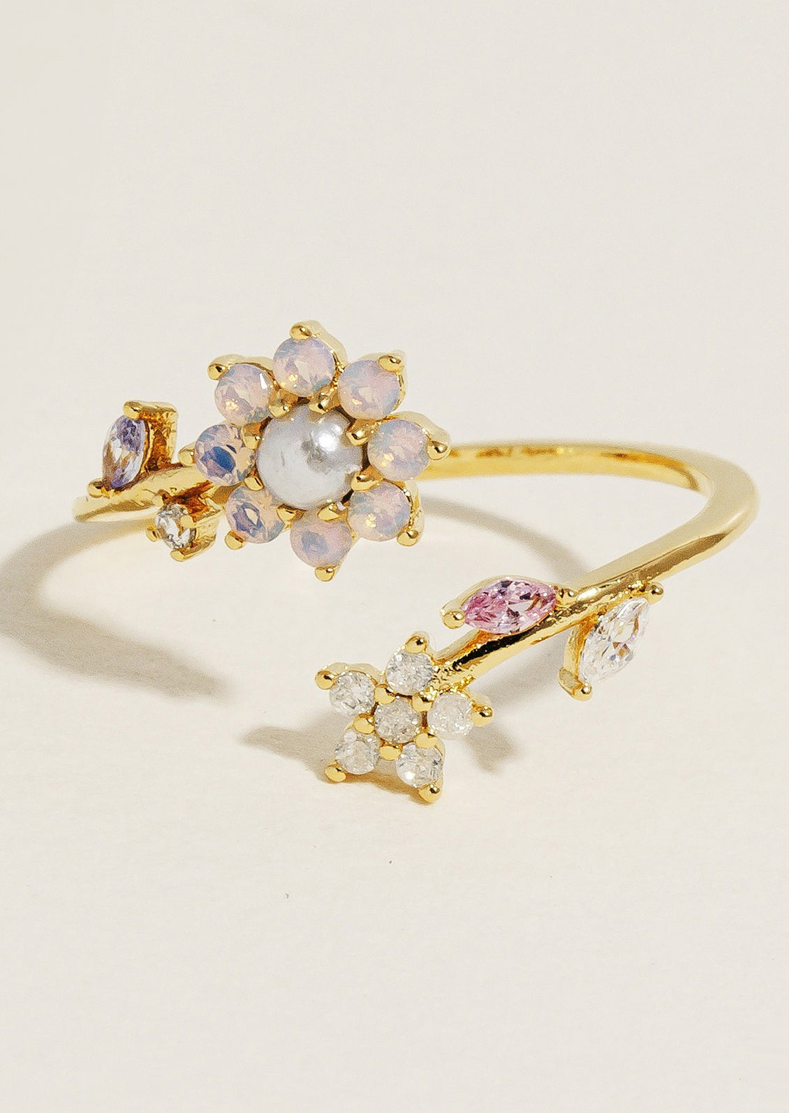 A gold ring with pearlescent crystal flowers.