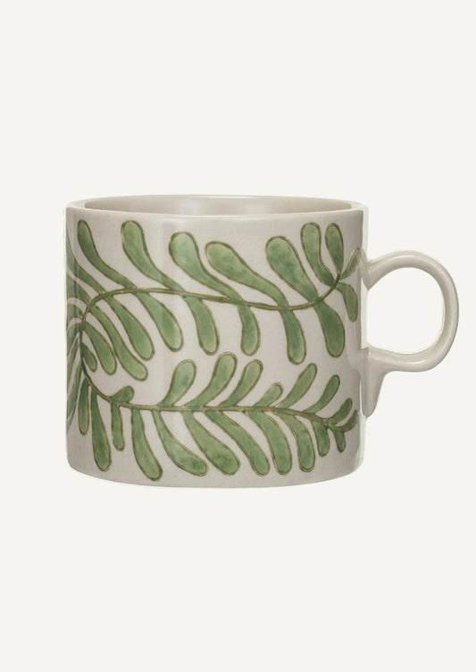 A white ceramic mug with green seaweed pattern.