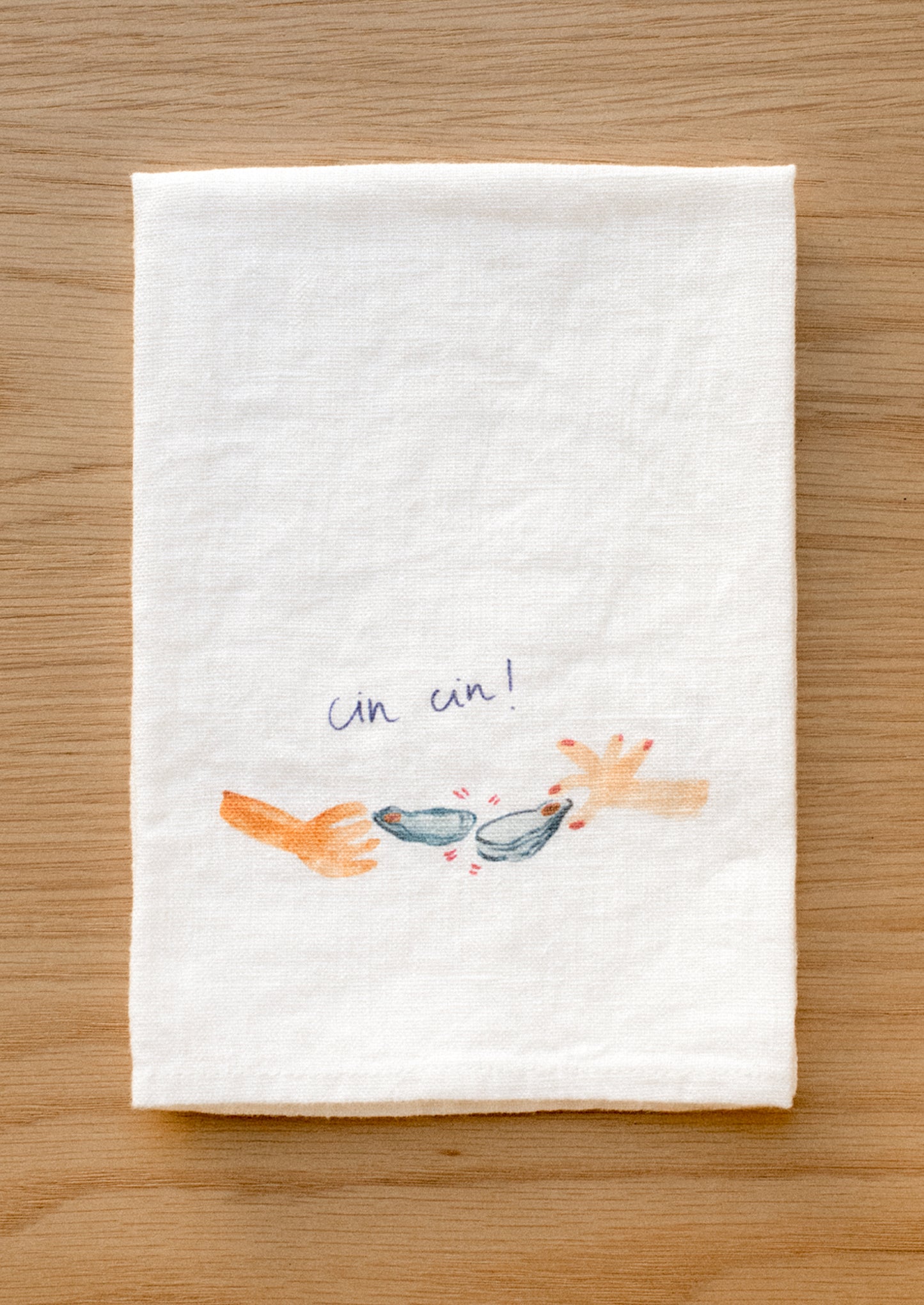 A white linen napkin with graphic detail of oyster cheers Cin Cin.