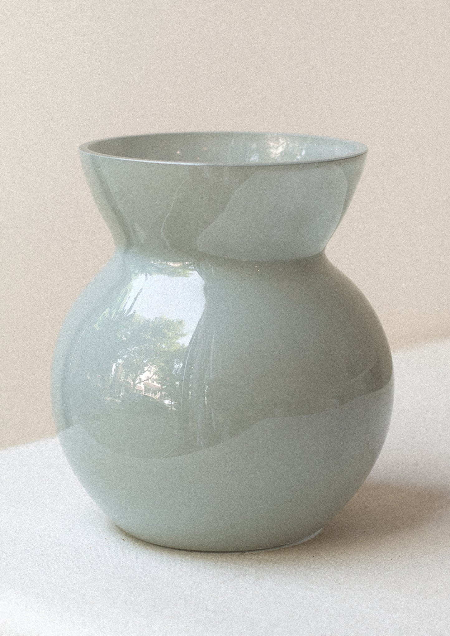 A glass vase in shiny light blue with tapered top.