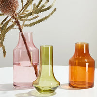 Amber: Three transparent glass vases in assorted colors and shapes.