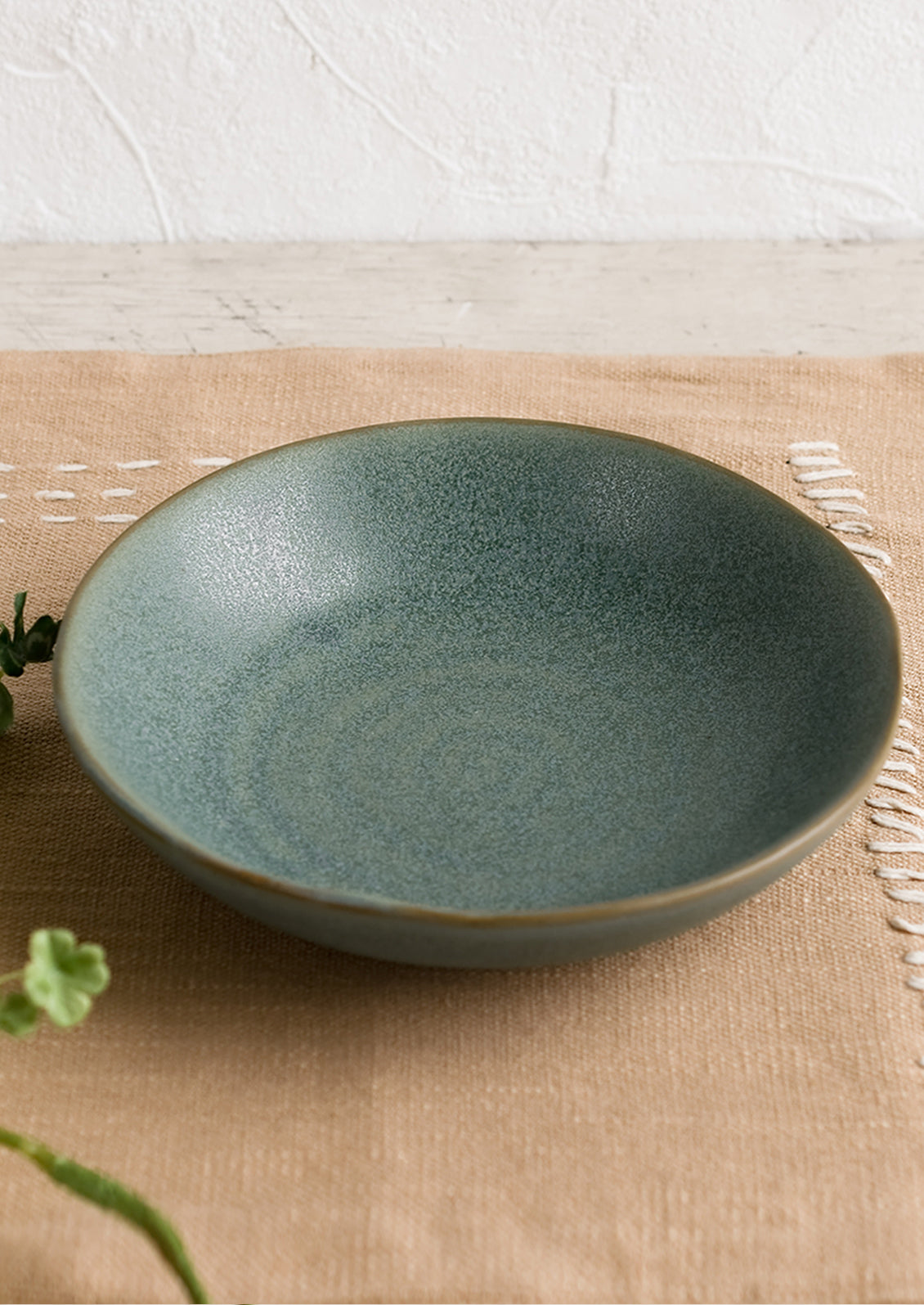 A mossy green-blue shallow ceramic bowl.