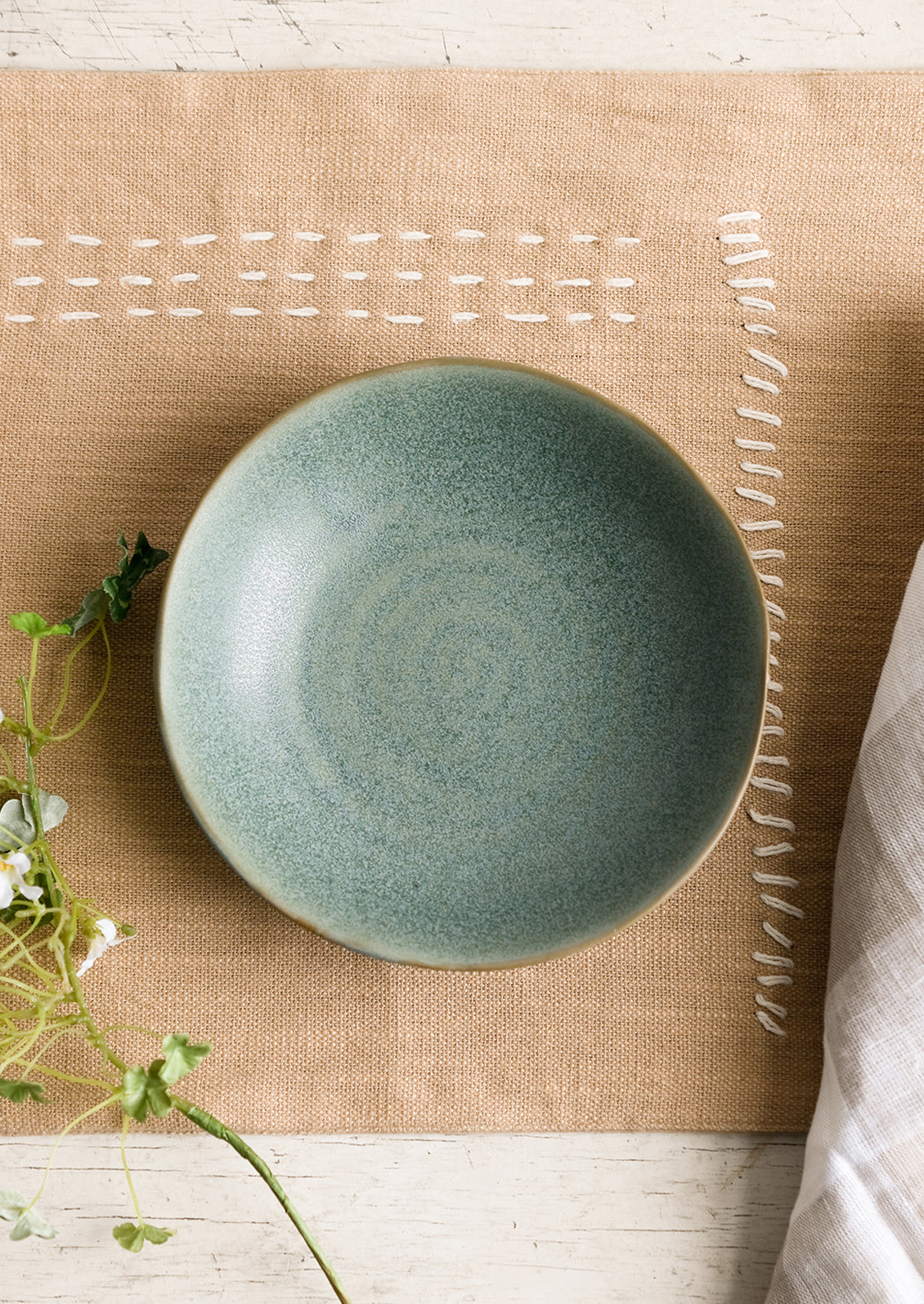 A mossy green-blue shallow ceramic bowl.