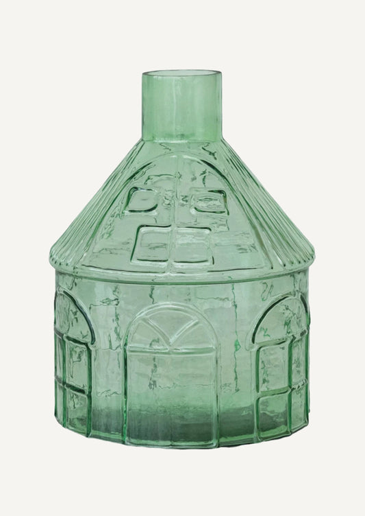 A glass vase in clear green glass shaped like a house.