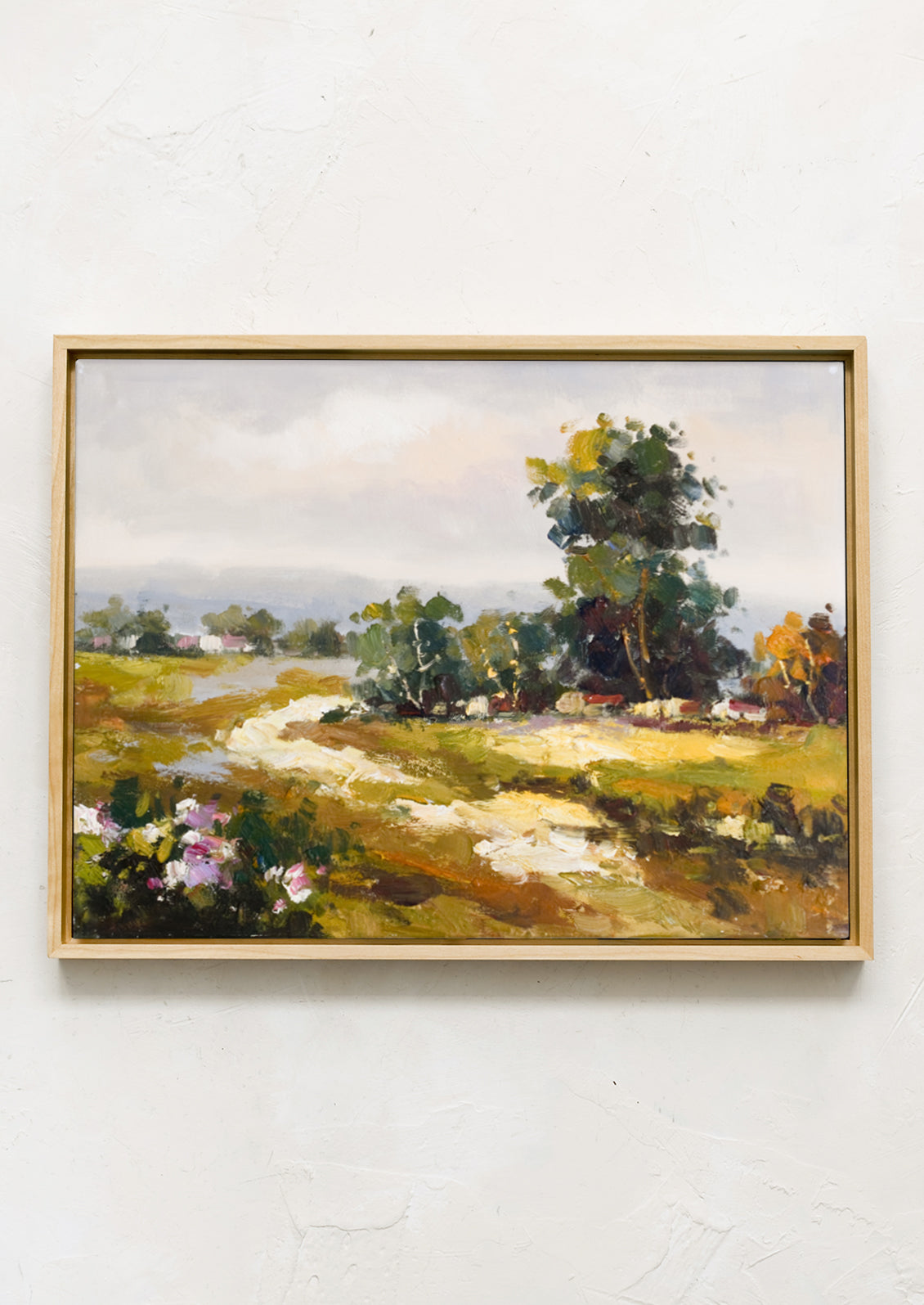 An original oil painting of countryside meadow in maple frame.