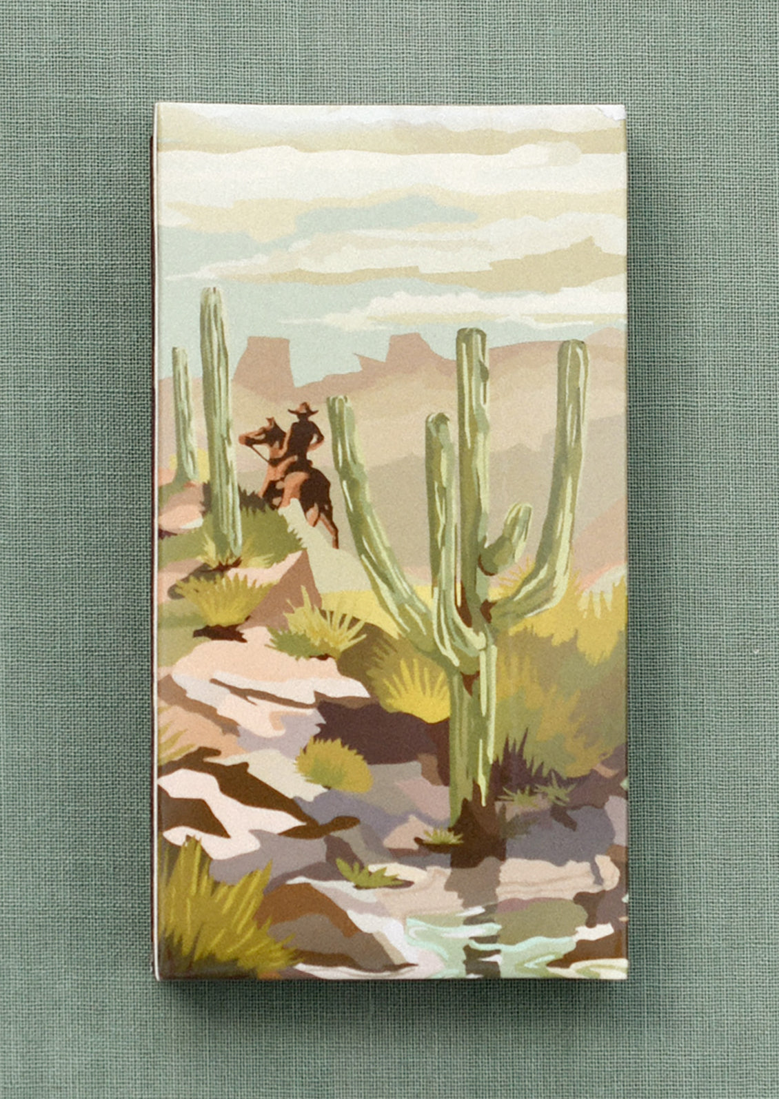 A printed matchbox with desert cowboy design.