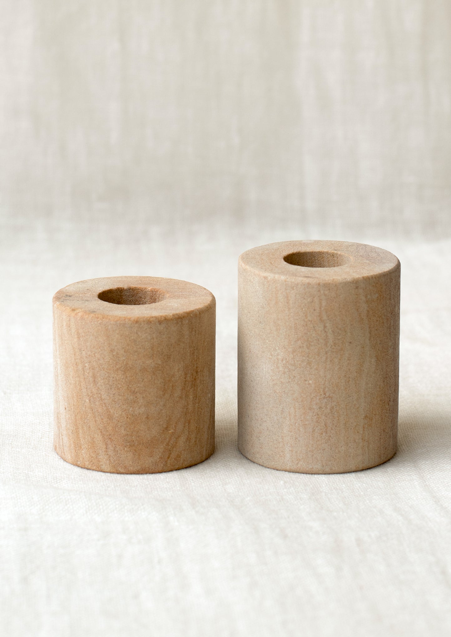 Cylindrical candleholders in two different height options, matte desert tan marble.