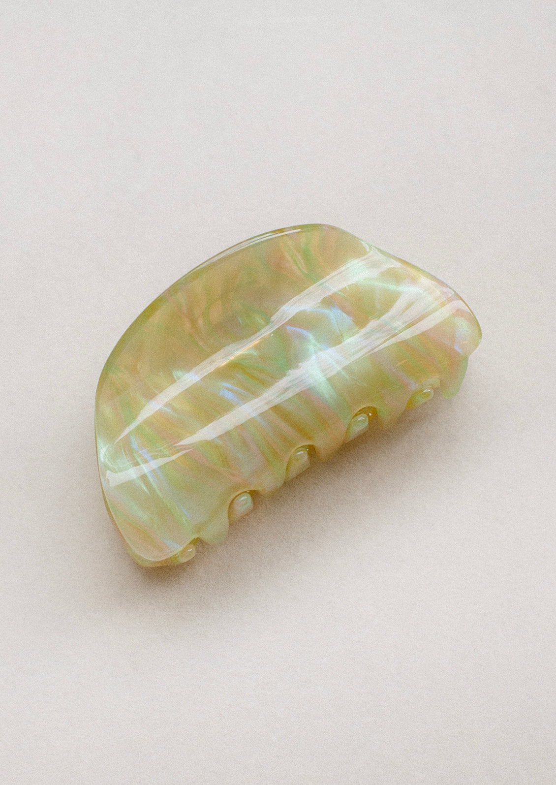 A curved hair claw in pearlescent yellow swirl.