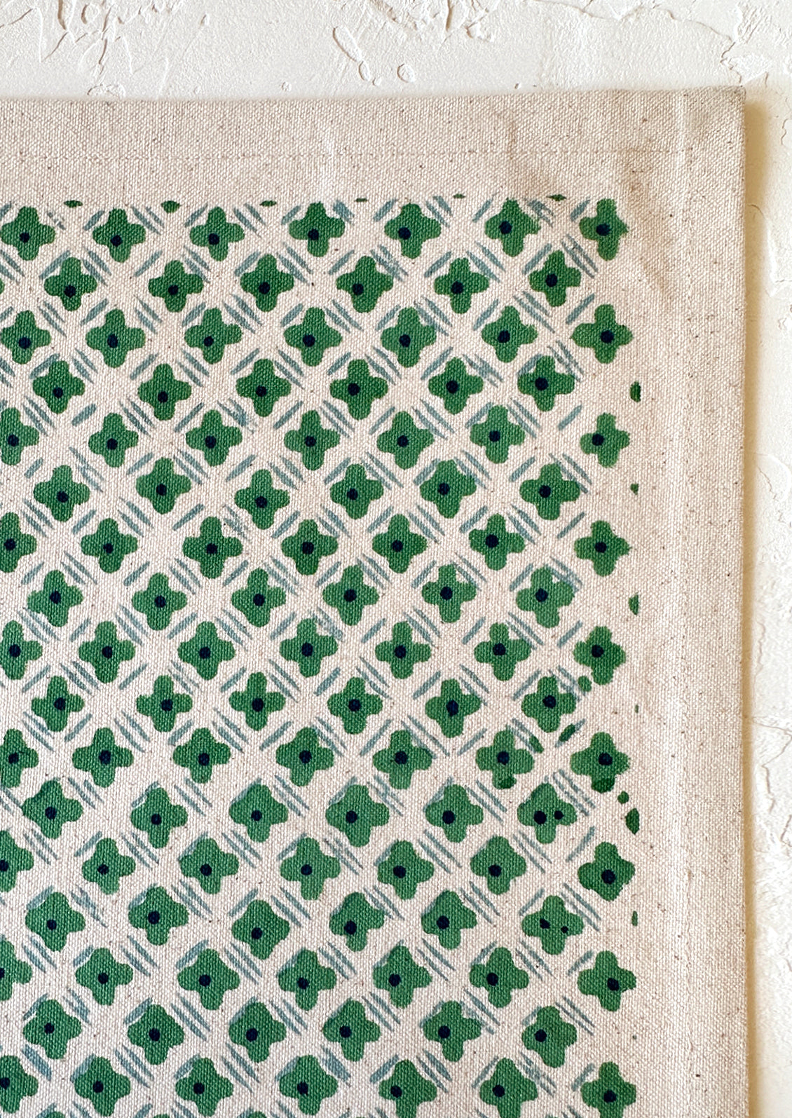 A placemat with tiny floral diamond formation pattern in green and light blue.