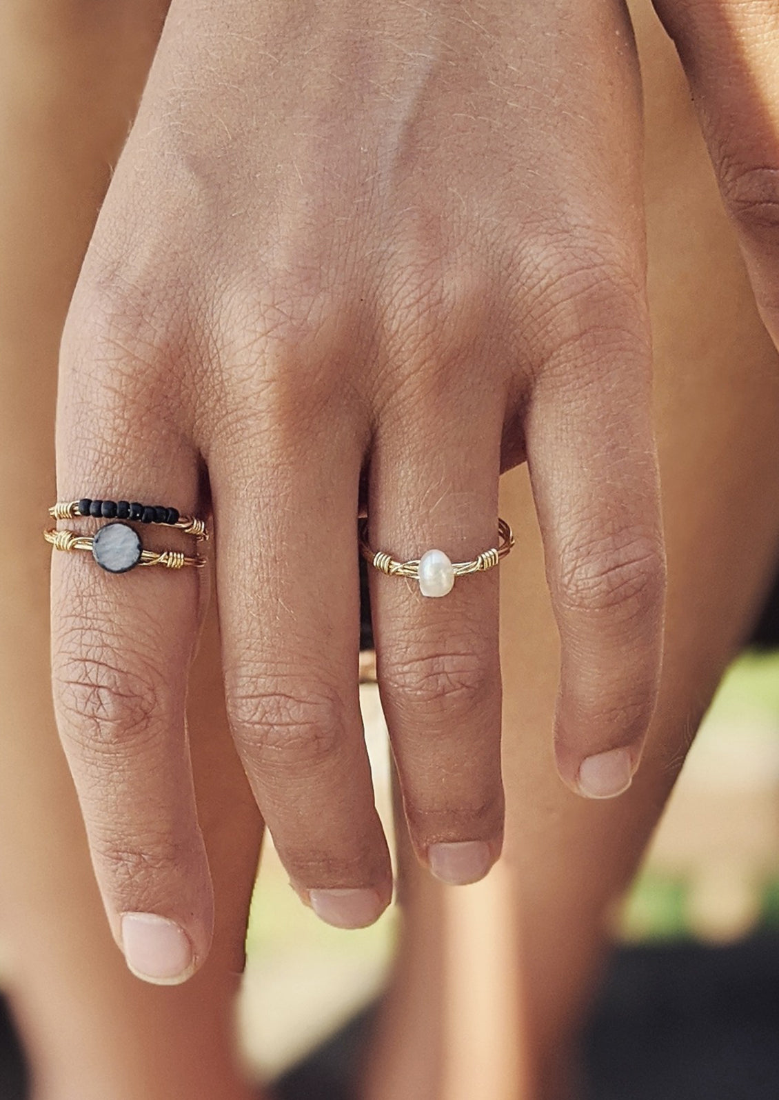 A gold wire ring with single pearl bead.