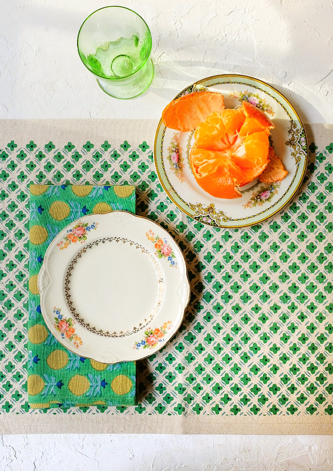 A placemat as part of a green themed table setting.