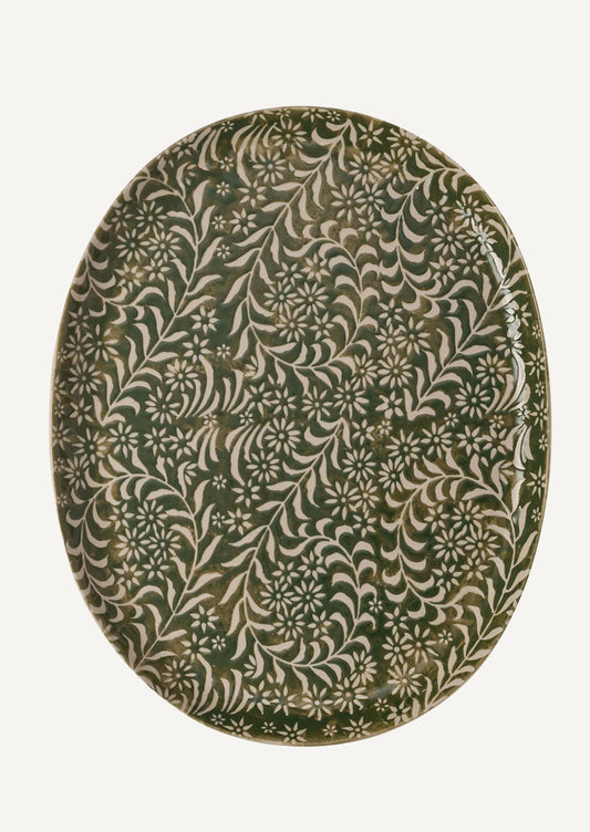 An oval shaped ceramic tray in green with botanical wax relief pattern.