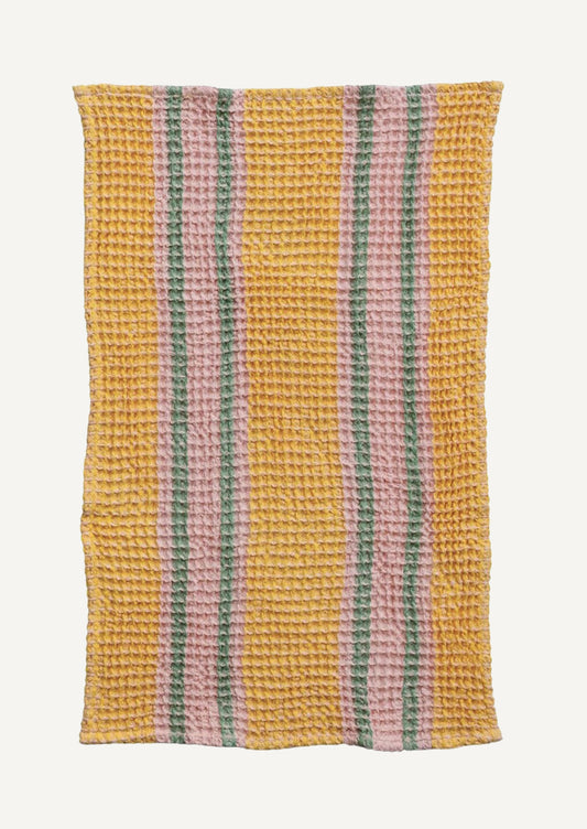 A waffle texture tea towel in yellow, pink and green stripe pattern.