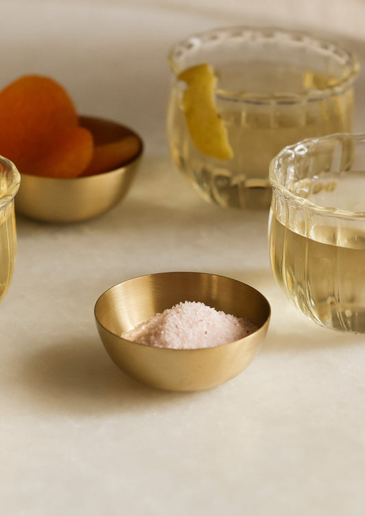 A mini brass bowl holding salt.