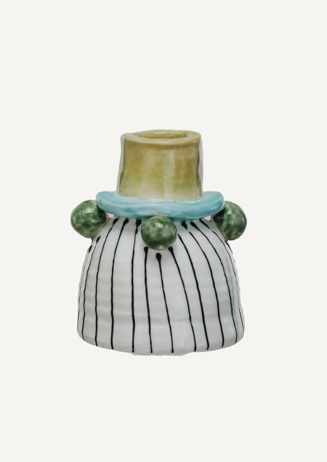 A ceramic candle holder with playful look, roughly in black and white stripe with green hobnail detailing.