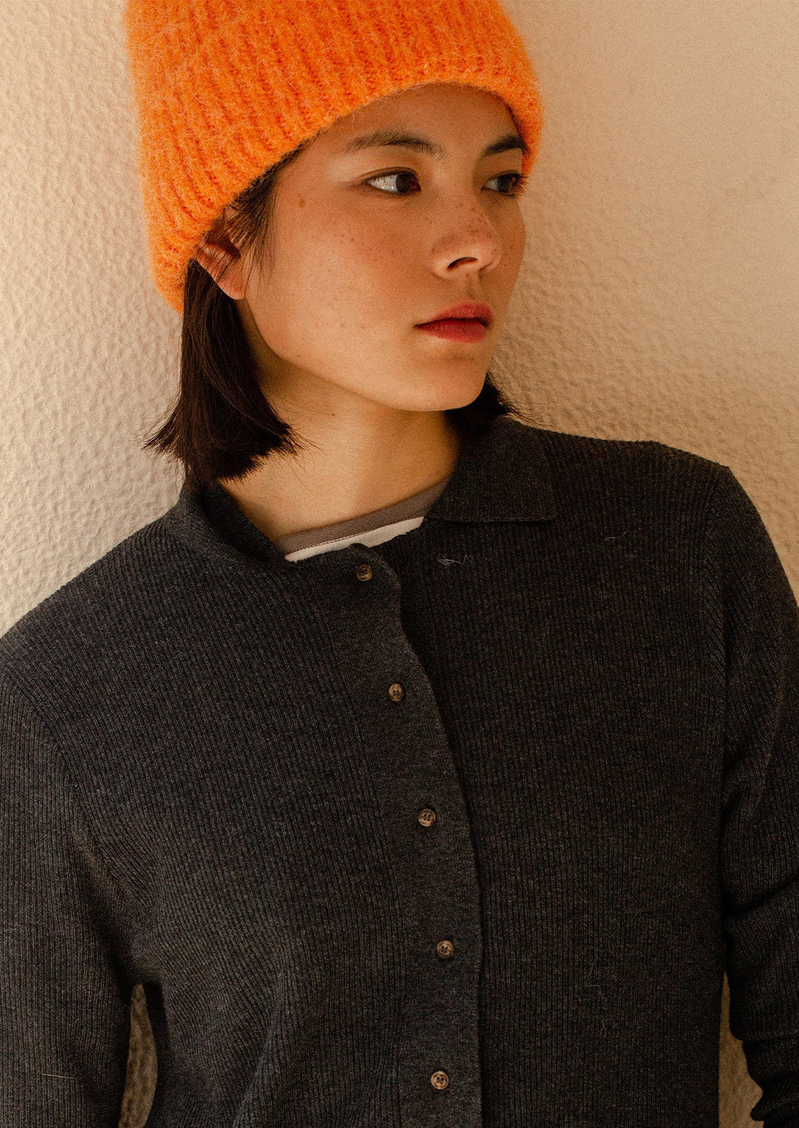 A woman wearing a beanie in orange.