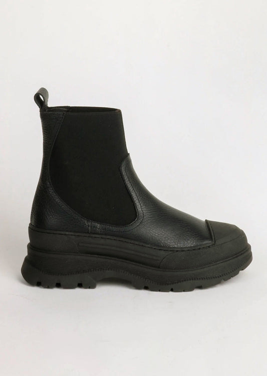 A pair of black boots with elastic ankle, rubber cap toe and chunky lug sole.