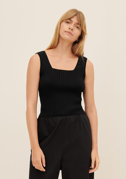 A person wearing a sleeveless, square neck rib knit top in black.